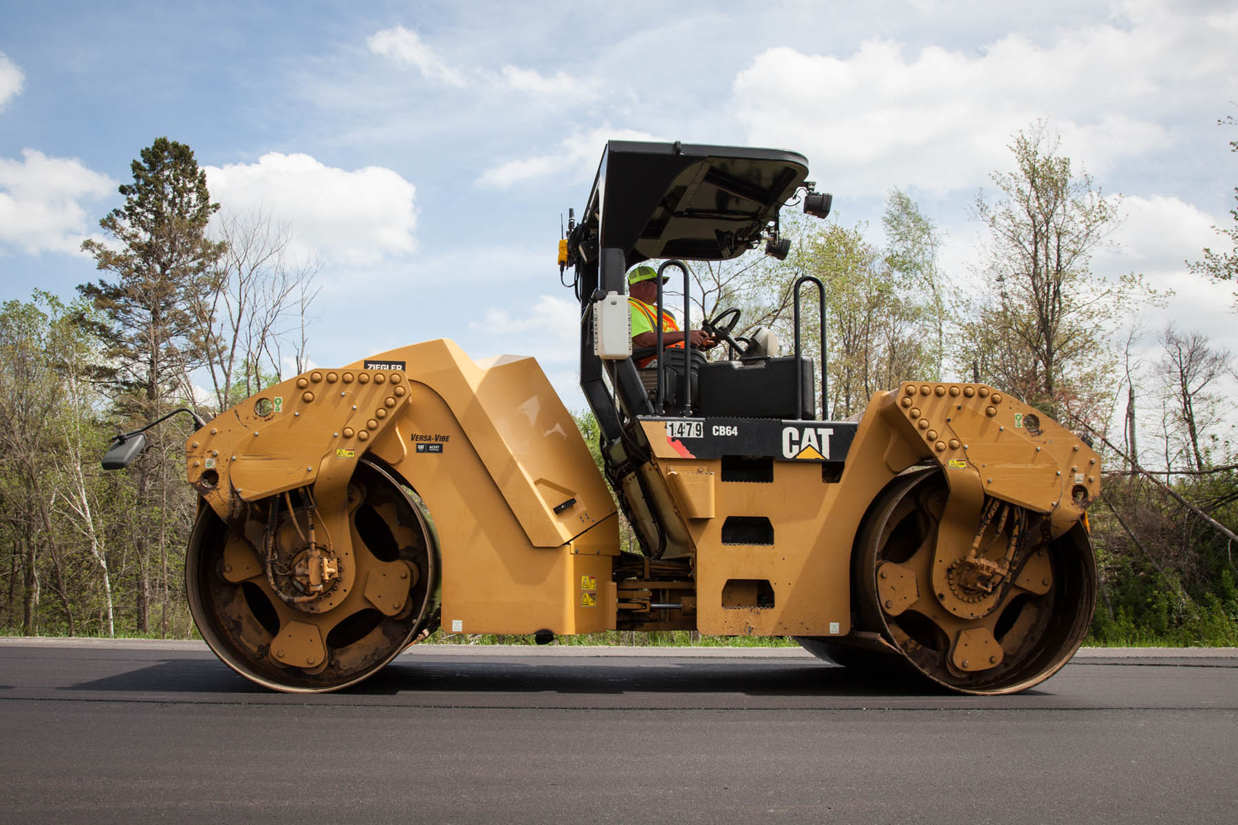 Profile of employee driving Caterpillar steamroller