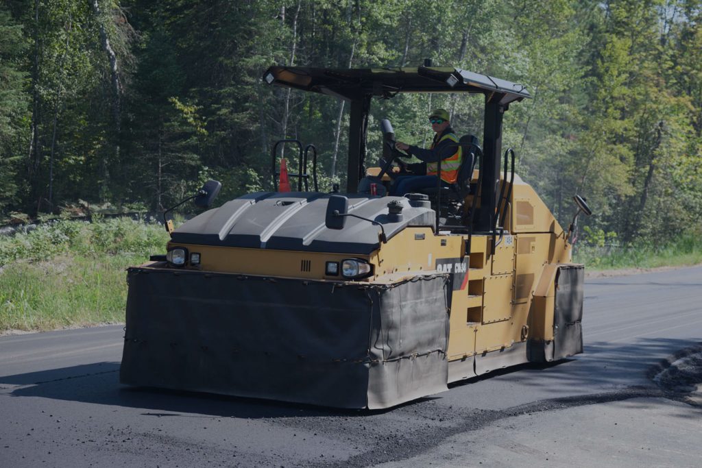 Steamroller flattening asphalt on country road
